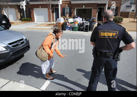 15. März 2011 - Norcross, GEORGIA, plädiert US - Distressed resident Catrina Adams (L) mit Sergeant Greg Chapel der Gwinnett County Sheriff Office Zivilgericht Division, wie eine gemietete Crew bringt alle Besitztümer der Familie an den Straßenrand schnell wie eine Räumung in Norcross, Georgia USA zugestellt wurde Stockfoto