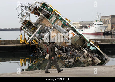 2. April 2011 geht - Iwaki, Japan - ein Mann durch eine beschädigte Mitglieder der selbst-Verteidigung-Kräfte und Feuerwehrleute Suche nach vermissten Personen in das Katastrophengebiet in Iwaki, Fukushimapräfektur, Japan. 3 Tage vom 1. April, Japan und US-Streitkräfte gemeinsam Suche nach verschwundenen durch Tsunami und Ea Stockfoto