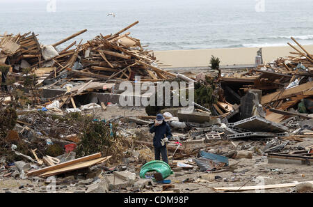 2. April 2011 - Narahara, Japan - geht ein Mann unter den beschädigten Haus von dem Erdbeben und dem Tsunami in Iwaki, Fukushimapräfektur, Japan ist reduziert. 3 Tage vom 1. April, Japan und US-Streitkräfte gemeinsam Suche nach verschwundenen durch Tsunami und Erdbeben sowohl von Himmel und Meer. Noch 16000 pe Stockfoto