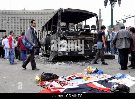 Ägypter sammeln vorbei an einem verbrannten LKW auf dem Tahrir-Platz in Kairo am 9. April 2011 folgende Auseinandersetzungen in der zwei Menschen getötet und mindestens 18 Jahre alt verwundet, als ägyptische Militär Polizei die Hauptstadt ikonischen Quadrat stürmten, anspruchsvolle Abfahrt des vorläufigen militärischen Herrscher Ägyptens Demonstranten zu zerstreuen Stockfoto