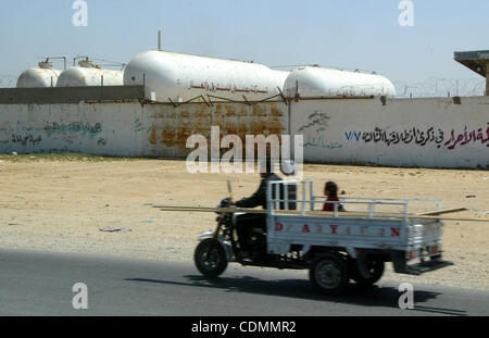 11. April 2011 - Rafah, Gaza-Streifen, Palästinensische Autonomiegebiete - A palästinensischen Mann sein Motorrad hinter einem geschlossenen Erdgasstation in Rafah, südlichen Gazastreifen reitet, wie Gazastreifen leidet unter dem Mangel an Erdgas die Enklave Streifen aus Israel geben. (Kredit-Bild: © Abed Rahim Khatib/a Stockfoto