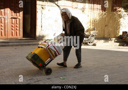 Ein palästinensischer Mann füllen Flaschen mit Wasser aus einer öffentlichen Wasserhahn in der United Nations Relief and Works Agency (UNRWA) zentrale im Flüchtlingslager Rafah im südlichen Gazastreifen am 26. April 2011. Foto von Ari Rahim Khatib Stockfoto