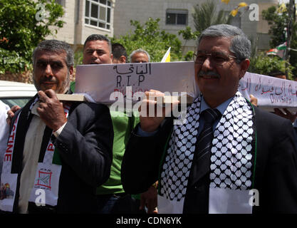 Schauen-Alikes Palestinian Authority President Mahmud Abbas (R) und Hamas-Führer Khaled Meshaal tragen einen mock Sarg für den Tod der palästinensischen politischen Abteilung während einer Kundgebung von Anhängern von Abbas' Fatah-Partei und Meshaals Hamas islamische Gruppe am 6. Mai 2011, in der West Bank-villa Stockfoto