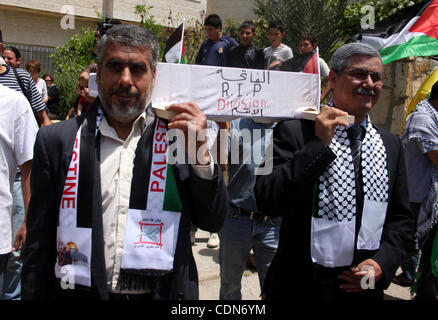 Schauen-Alikes Palestinian Authority President Mahmud Abbas (R) und Hamas-Führer Khaled Meshaal tragen einen mock Sarg für den Tod der palästinensischen politischen Abteilung während einer Kundgebung von Anhängern von Abbas' Fatah-Partei und Meshaals Hamas islamische Gruppe am 6. Mai 2011, in der West Bank-villa Stockfoto