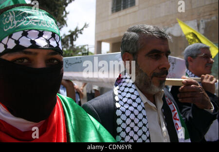 Schauen-Alikes Palestinian Authority President Mahmud Abbas (R) und Hamas-Führer Khaled Meshaal tragen einen mock Sarg für den Tod der palästinensischen politischen Abteilung während einer Kundgebung von Anhängern von Abbas' Fatah-Partei und Meshaals Hamas islamische Gruppe am 6. Mai 2011, in der West Bank-villa Stockfoto