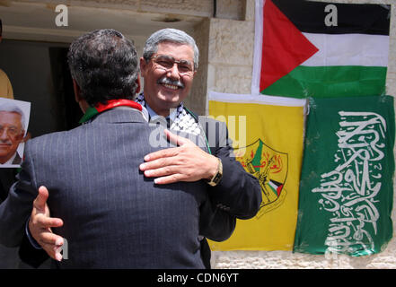 Schauen-Alikes Palestinian Authority President Mahmud Abbas (R) und Hamas-Führer Khaled Meshaal umarmen während einer Kundgebung von Anhängern der Abbas' Fatah-Partei und Meshaals Hamas islamische Gruppe am 6. Mai 2011, in der West Bank Dorf von Bilin, anlässlich den politischen Einheit Versöhnung Deal zwischen der Stockfoto