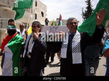 Schauen-Alikes Palestinian Authority President Mahmud Abbas (R) und Hamas-Führer Khaled Meshaal tragen einen mock Sarg für den Tod der palästinensischen politischen Abteilung während einer Kundgebung von Anhängern von Abbas' Fatah-Partei und Meshaals Hamas islamische Gruppe am 6. Mai 2011, in der West Bank-villa Stockfoto