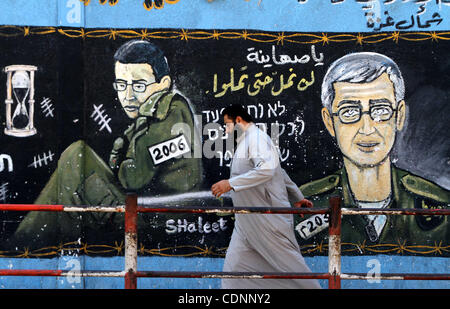 23. Juni 2011 - demonstriert Gaza-Stadt, Gaza-Streifen - A palästinensischen Mann Vergangenheit geht ein Wandbild mit israelischen Soldaten Gilad Shalit in Jabalya im nördlichen Gazastreifen als Demonstranten erfasst außerhalb der Geschäftsräume des IKRK in Gaza-Stadt. Das Internationale Rote Kreuz Emanded, das Hamas zeigen deutlich, dass Stockfoto