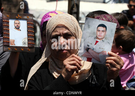 3. Juli 2011 - Ramallah, Westjordanland, Palästinensische Autonomiegebiete - hält eine Palästinenserin Bilder von ihren Verwandten in israelischen Gefängnissen während einer Protestaktion fordern ihre Freilassung in der Westbank-Stadt Ramallah am 3. Juli 2011 statt. Israel hält derzeit rund 5.600 palästinensischen Häftlinge in den Gefängnissen Stockfoto