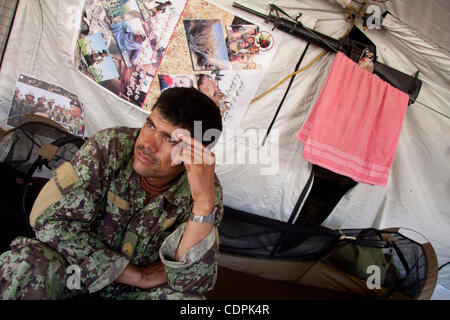 26. April 2011 - Kenjak-e Sofla, Helmand, Afghanistan - eine afghanische nationale Armee (ANA) Soldat sitzt auf seinem Bettchen in einem Zelt, das als seine Wohnräume bei einer Patrouille nahe dem Dorf von Kenjak-e Sofla im Naw Zad-Distrikt in der Provinz Helmand, Basis dient Afghanistan, Dienstag. Diese ANA-Einheit ist Partner von Stockfoto