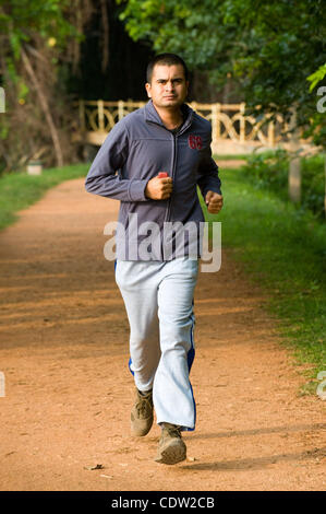 23. Mai 2011 - Mysore, Indien - 23. Mai 2011, Mysore, Indien - ein junger Mann joggt in der Nähe von einem See in Mysore, Indien, in einem Park namens Kukkarahalli Kere.  Fettleibigkeit sind auf dem Vormarsch in Indien. (Kredit-Bild: © David Snyder/ZUMAPRESS.com) Stockfoto