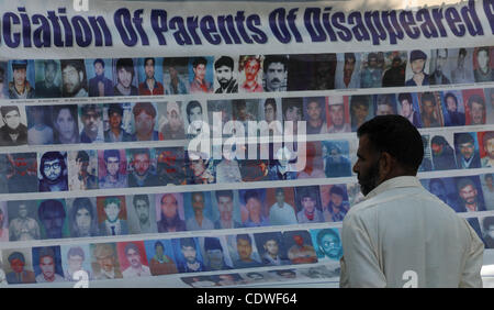 10. Juni 2011 schaut Fotos für seine fehlende relative bei einem Sit-in Protest in Srinagar am 10. Juni 2011 - Srinagar, Indien - A Relative des kaschmirischen Heranwachsenden, die verschwunden ist. Berichten zufolge, die der Vereinigung der Eltern von verschwunden Personen (APDP) von Parveena Ahanger Organi geleitet Stockfoto