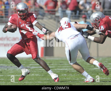 18. September 2011 - versucht Albuquerque, NEW MEXICO, USA - Roberto E. Rosales.Lobo Quarterback Tarean Austin (Cq), links, Weg von der Texas Tech Jackson Richards (Cq), Mitte. Das Spiel, das die Lobos 59 bis 13 schließlich verloren würde zweimal Samstag Nachmittag durch Blitzschlag verzögert werden... Albuquerque, neu Stockfoto