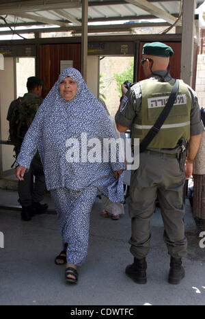 Eine Palästinenserin wird bei einer israelischen Armee-Checkpoint auf ihrem Weg zum Beten in der Ibrahimi-Moschee in der Westbank-Stadt Hebron, am 5. August 2011 überprüft. Muslime auf der ganzen Welt kennzeichnen den Monat Ramadan, in denen sie essen, trinken und Intimität mit ihren Partne zu unterlassen Stockfoto