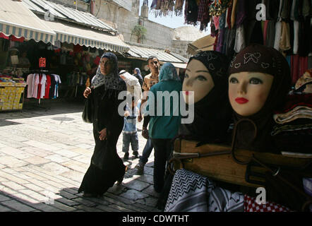 Israelische Grenze Wache (unsichtbaren) halten sehen Palästinenser, wie sie auf einem Markt in der Altstadt von Jerusalem am 8. August 2011 shop. Muslime auf der ganzen Welt kennzeichnen den Monat Ramadan, in denen sie essen, trinken und Intimität mit ihren Partnern vom Morgengrauen bis zur Abenddämmerung zu unterlassen. Foto: Stockfoto