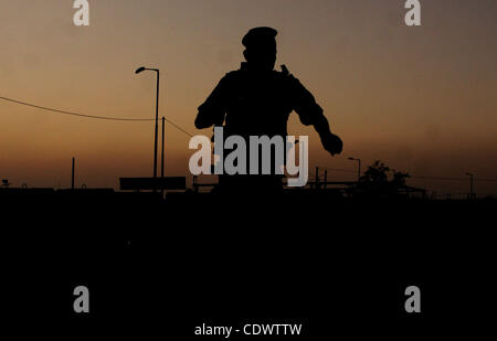 Ein israelischer Soldat steht Wache an Israels Qalandiya Checkpoint, wie Palästinenser warten in Jerusalem aus dem Checkpoint außerhalb der Westbank Ramallah, während am zweiten Freitag des Heiligen Monats Ramadan 12. August 2011 zu überqueren... Foto von Issam Rimawi Stockfoto