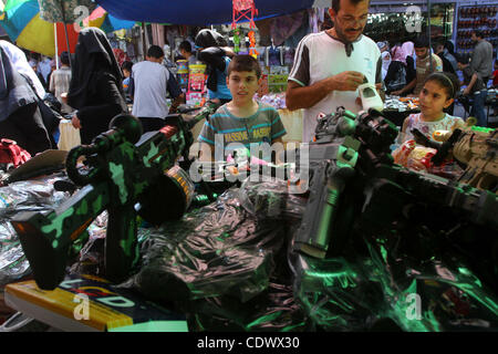 29. August 2011 - Gaza-Stadt, Gaza-Streifen - palästinensischen Anbieter anzeigen Spielzeug Maschinengewehre und waren zum Verkauf während der Vorbereitungen für Eid al-Fitr am Hauptmarkt in Gaza-Stadt. Muslime auf der ganzen Welt zu kaufen, Kleidung, Süßigkeiten und andere beliebte Artikel zur Vorbereitung der Eid aL-Fitr, das feste marki Stockfoto