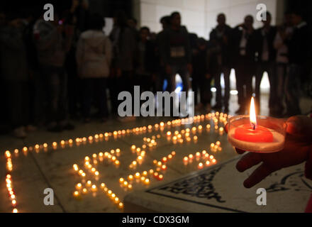 11. November 2011 - Ramallah, Westjordanland, Palästinensische Autonomiegebiete - Kränze Palästinenser legen Blumen und Kerzen am Grab des verstorbenen palästinensischen Führer Yasser Arafat am siebten Jahrestag seines Todes in der Westbank Ramallah am 11. November 2011, als Palästinenser gesammelt für eine Kerze-li Stockfoto