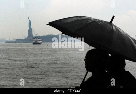 25. August 2011 Boot - Manhattan, New York, USA - Menschen mit Regenschirmen, die Statue of Liberty zu bereisen, wie Hurrikan Irene auf der östlichen Meeresküste Kannen. (Bild Kredit: Bryan Smith/ZUMAPRESS.com ©) Stockfoto