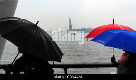 25. August 2011 Boot - Manhattan, New York, USA - Menschen mit Regenschirmen, die Statue of Liberty zu bereisen, wie Hurrikan Irene auf der östlichen Meeresküste Kannen. (Bild Kredit: Bryan Smith/ZUMAPRESS.com ©) Stockfoto