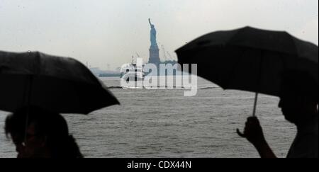 25. August 2011 Boot - Manhattan, New York, USA - Menschen mit Regenschirmen, die Statue of Liberty zu bereisen, wie Hurrikan Irene auf der östlichen Meeresküste Kannen. (Bild Kredit: Bryan Smith/ZUMAPRESS.com ©) Stockfoto