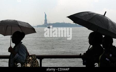 25. August 2011 Boot - Manhattan, New York, USA - Menschen mit Regenschirmen, die Statue of Liberty zu bereisen, wie Hurrikan Irene auf der östlichen Meeresküste Kannen. (Bild Kredit: Bryan Smith/ZUMAPRESS.com ©) Stockfoto