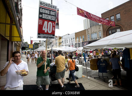 23. Juli 2011 - hält Ann Arbor, Michigan, USA - David Gill von Wayne, MI, ein Going-Out-of-Business-Schild in der Nähe das Flaggschiff Grenzen Buchhandlung während der State Street Art Fair in der Innenstadt von Ann Arbor, MI am 23. Juli 2011.  Grenzen-Gruppe hat vor kurzem angekündigt, die Schließung von 399 Shops und 10.700 Mitarbeiter layo Stockfoto