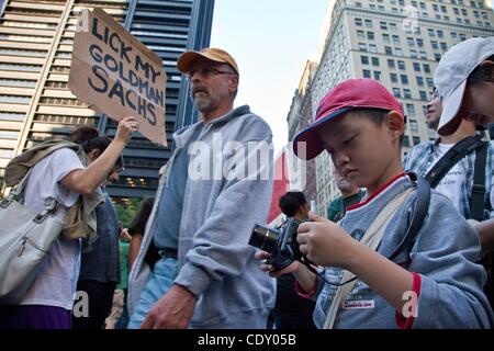 8. Oktober 2011 bereitet - New York, New York, USA - ein junger junge mit seinen Eltern, die Aktivitäten zu fotografieren, wie Touristen zu stoppen, um auf der Website der Occupy Wall Street in Lower Manhattan suchen. Occupy Wall Street-Website sagt die Gruppe ist ein '' führerlos Widerstandsbewegung mit Menschen aus vielen Farben, ge Stockfoto