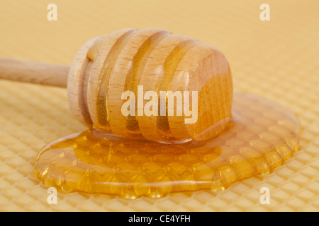 verschüttete Honig mit einem Holzlöffel auf Hintergrund Stockfoto