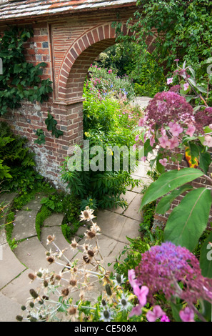 Ein Torbogen durch einen ummauerten Garten. Stockfoto