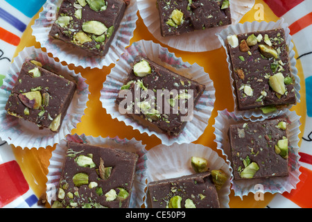 Hausgemachte Schokolade und Pistazien Fudge in Fällen auf bunte Platte Stockfoto
