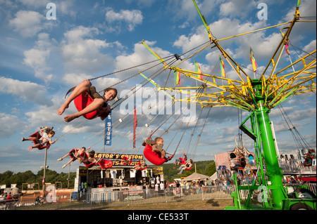 Kinder auf der Schaukel schwingt fahren vor blauen Himmel auf Mason-Dixon-Messe Stockfoto