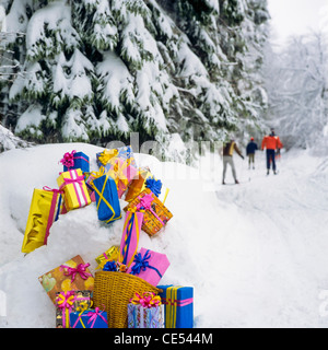 Weihnachtsgeschenke auf Schnee von Tannen, Langläufer in der Ferne, im Elsass, Frankreich, Europa Stockfoto