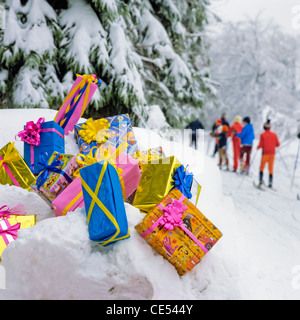 Weihnachtsgeschenke auf Schnee von Tannen, Langläufer in der Ferne, im Elsass, Frankreich, Europa Stockfoto