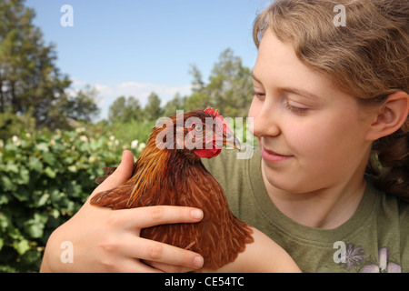 Teenager-Mädchen halten und lieben ein Haustier Henne Huhn Stockfoto