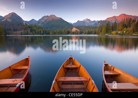 Ruderboote und Bergen unter einem Himmel der Dämmerung, Strbske Pleso See in der hohen Tatra, Slowakei, Europa. Stockfoto