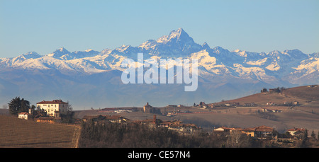 Panoramablick auf kleinen Dorf auf den Hügeln gegen Alp Berge mit schneebedeckten Gipfeln in Nordirland, Italien. Stockfoto