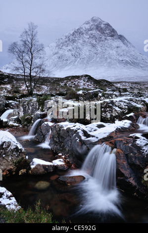 Wasserfall auf dem Fluss Coupall mit Buachaille Etive Mor im Hintergrund. Winter-Blick in Glencoe, Schottisches Hochland Stockfoto