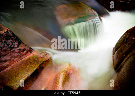 Lange Belichtung des Flusses Nevis. Wasser rauscht über die bunten Felsen und Geröll. Fort William Schottisches Hochland, Großbritannien Stockfoto