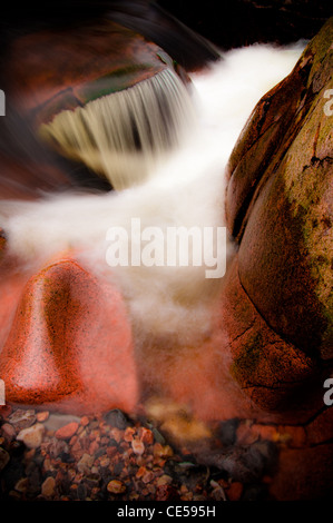 Lange Belichtung des Flusses Nevis. Wasser rauscht über die bunten Felsen und Geröll. Fort William Schottisches Hochland, Großbritannien Stockfoto
