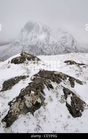 Schnee und Felsen auf Stob Beinn ein Chrulaiste, Glencoe, Schottisches Hochland, mit Buachaille Etive Mor im Hintergrund Stockfoto