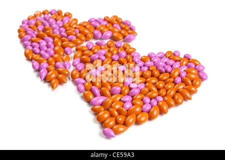 Zwei Herzformen von Dragee Bonbons isoliert auf weißem Hintergrund Stockfoto