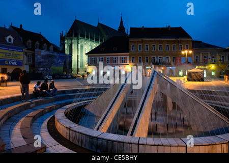 Europa, Rumänien, Brasov, die Nachtansicht des Brunnens auf dem Sfatului Platz mit der gotischen Balck Kirche im Hintergrund Stockfoto