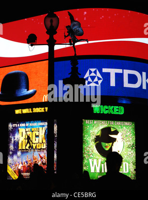 Statue des Eros nach Einbruch der Dunkelheit gegen beleuchteten Werbetafeln am Piccadilly Circus in London, England, zu Weihnachten. Stockfoto