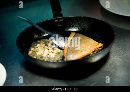 Fisch und Mandeln in einer Pfanne gekocht wird Stockfoto