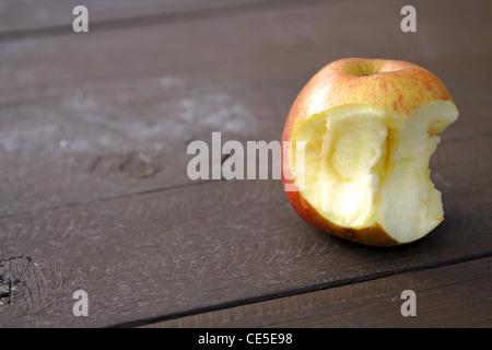 Stillleben mit eine angebissene Apfel auf einem Holztisch im Wald. Stockfoto