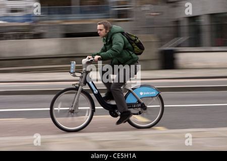 ein Radfahrer, der auf einem Fahrrad Boris Reiten entlang einer Straße in London Stockfoto