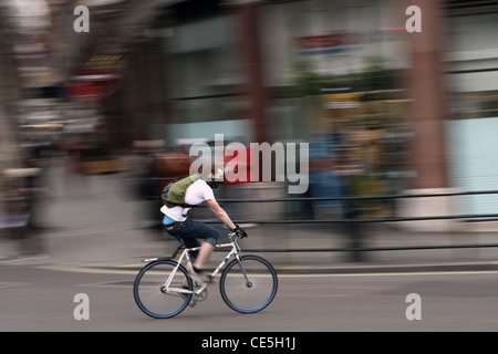 ein Radsportler entlang einer Straße in London, tragen eine Atemmaske Stockfoto