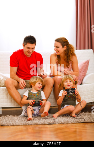 Zwillinge-Töchter spielen auf Konsole zu Hause Stockfoto