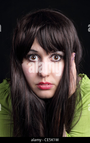 Mädchen; Frau; Dame; Schwarzes Haar; schwarzem Hintergrund; Porträt; Gesicht; Perücke; große Augen; grüne Augen; grüne Spitze; Angst vor Mädchen; Stockfoto